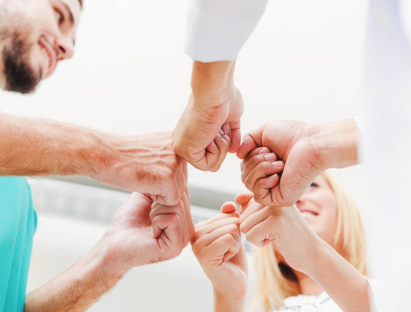 Symbolbild von Pflegekräften, welche die Hände zusammenführen